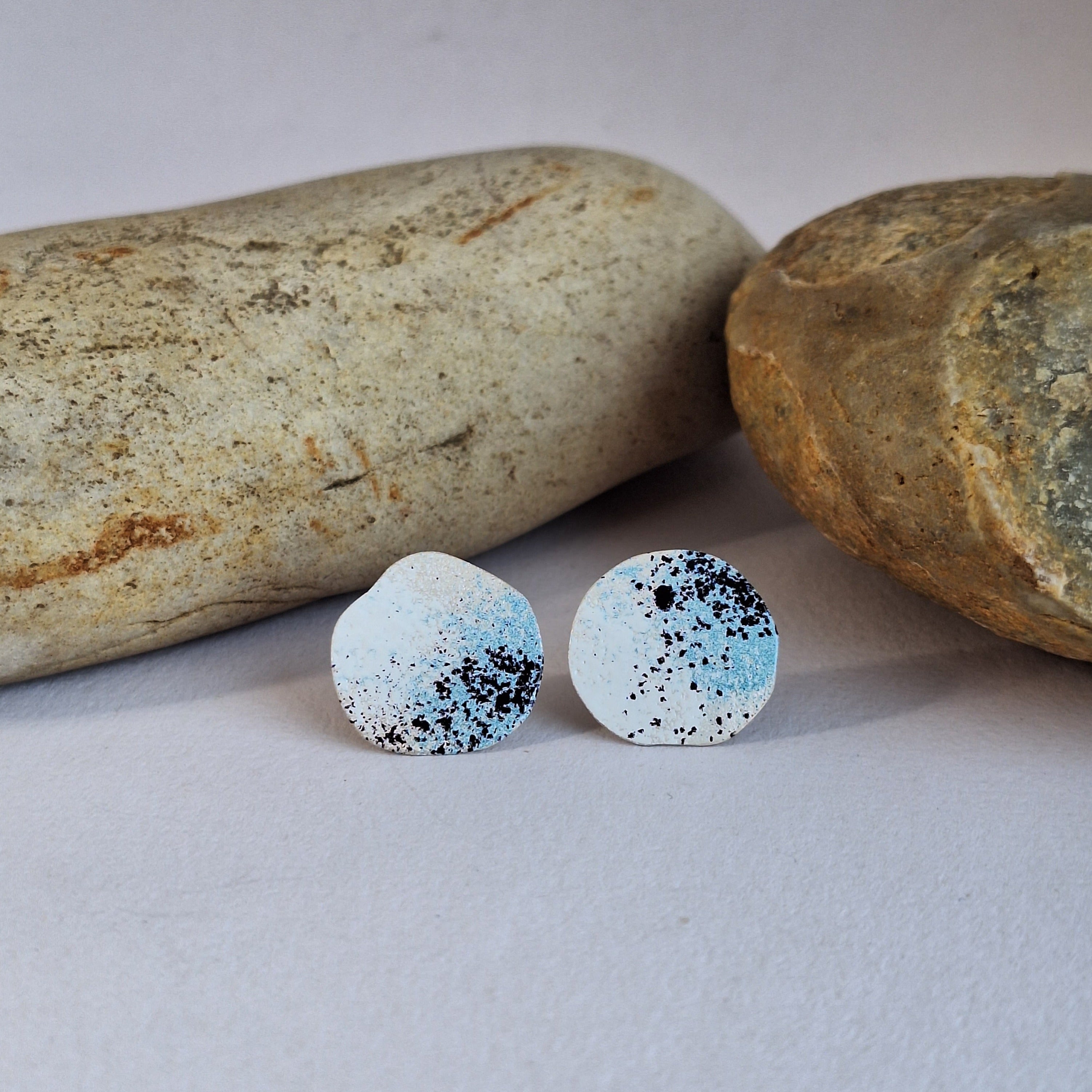 Sterling silver stud earring with blue white and black powder coat to represent lichen.