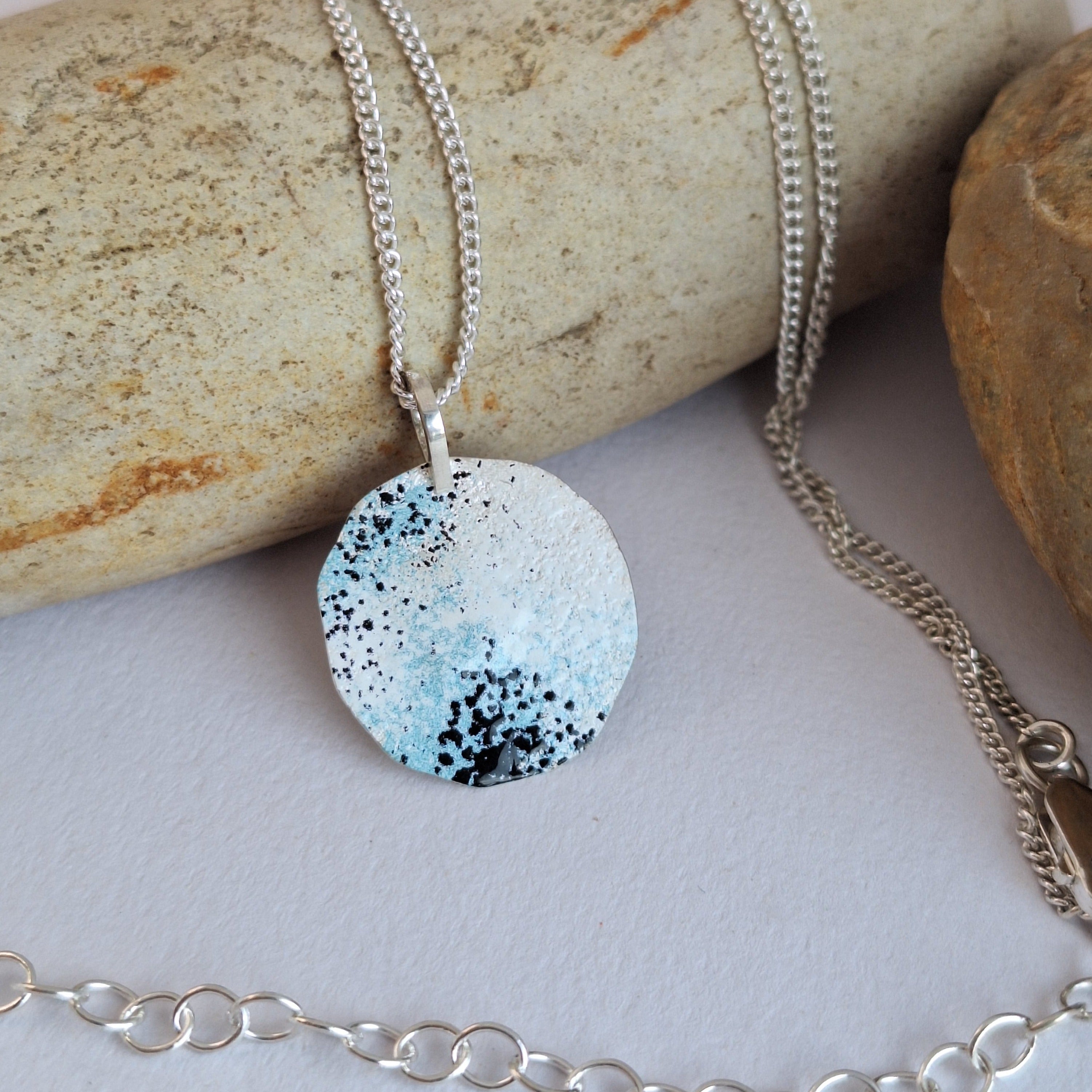 Sterling silver necklace with blue, white and black powder coat representing lichens.