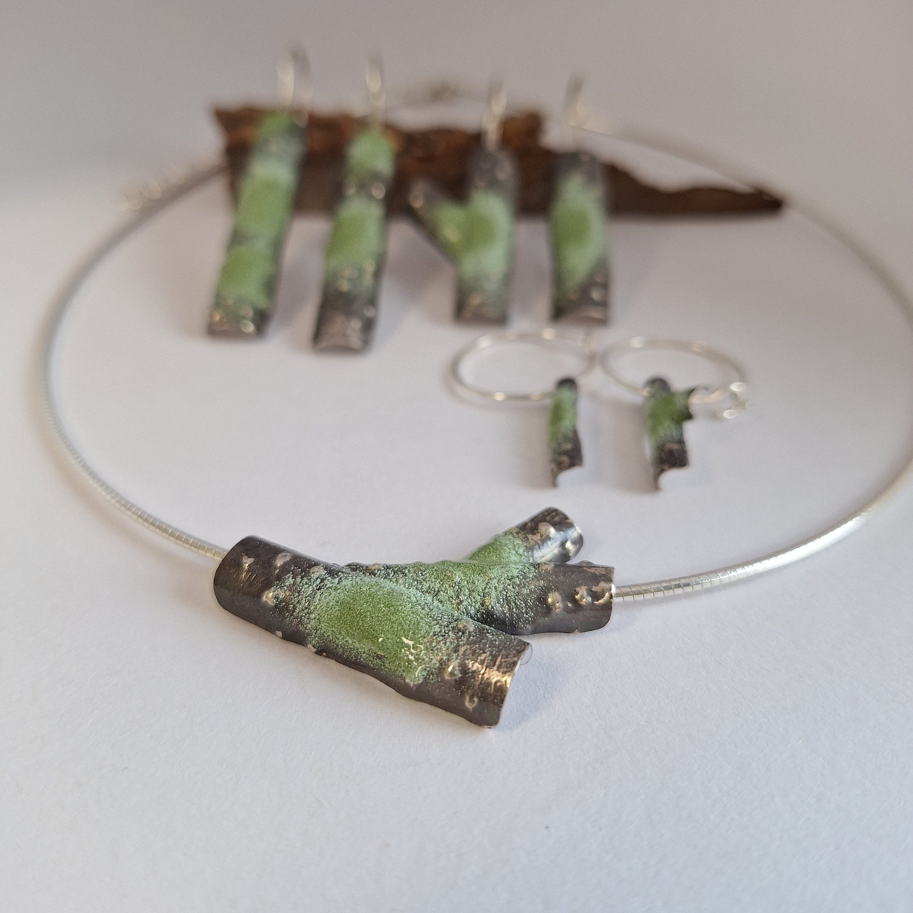 Oxidised Sterling silver branch necklace with green powder coat on a white surface