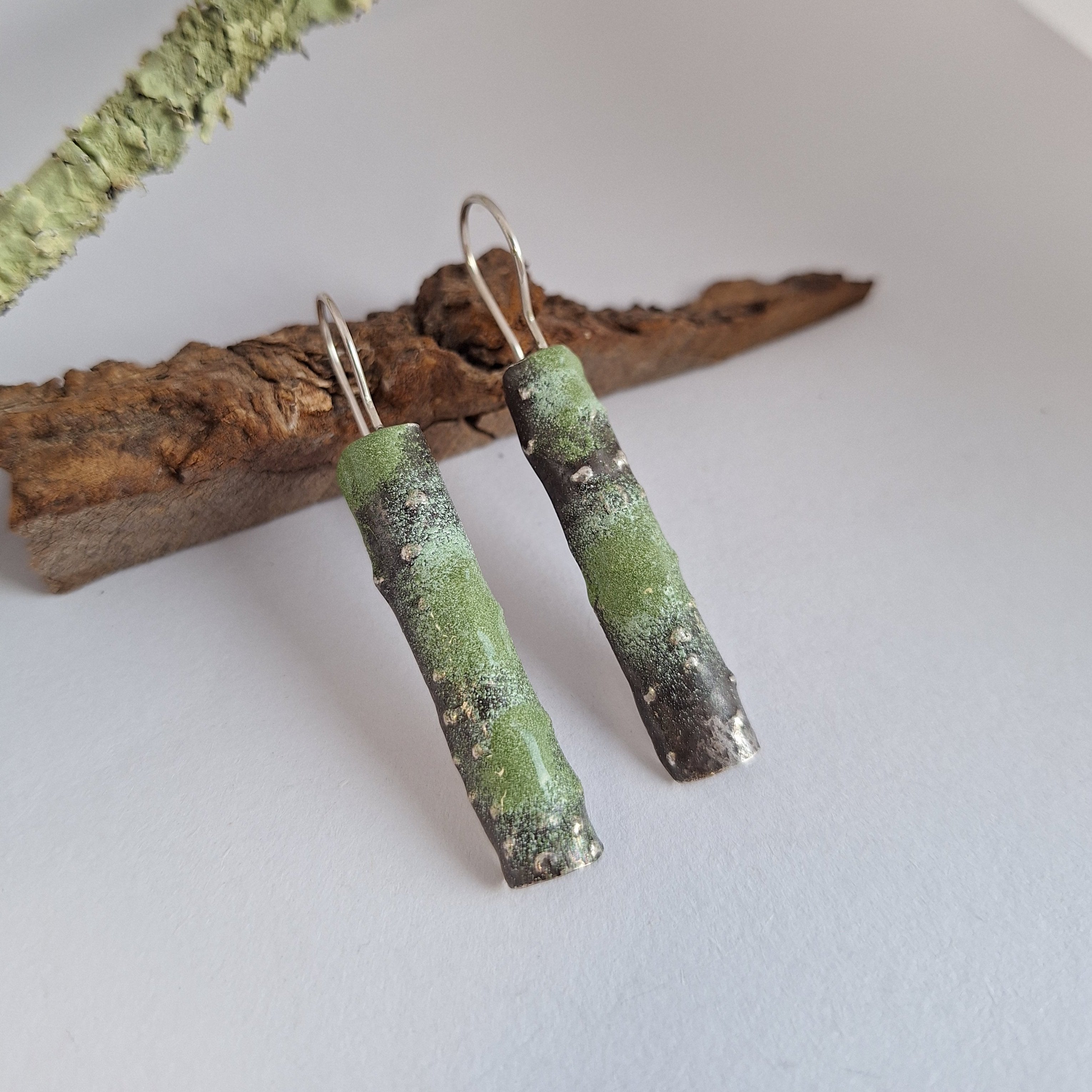 Oxidised Sterling silver branch earrings with green powder coat on a white surface