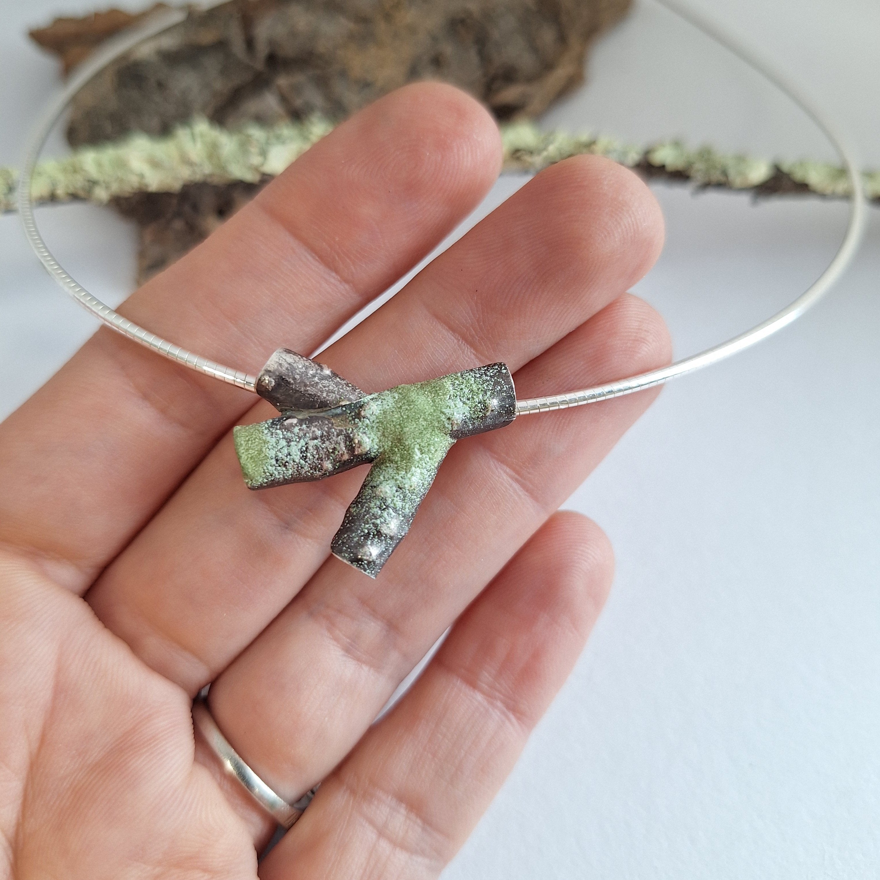 Sterling silver twig branch tree necklace with powder coated lichen on hand