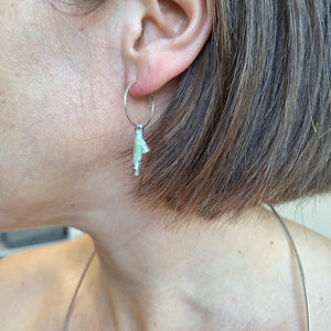 Sterling silver twig earring with powder coated lichen on ear