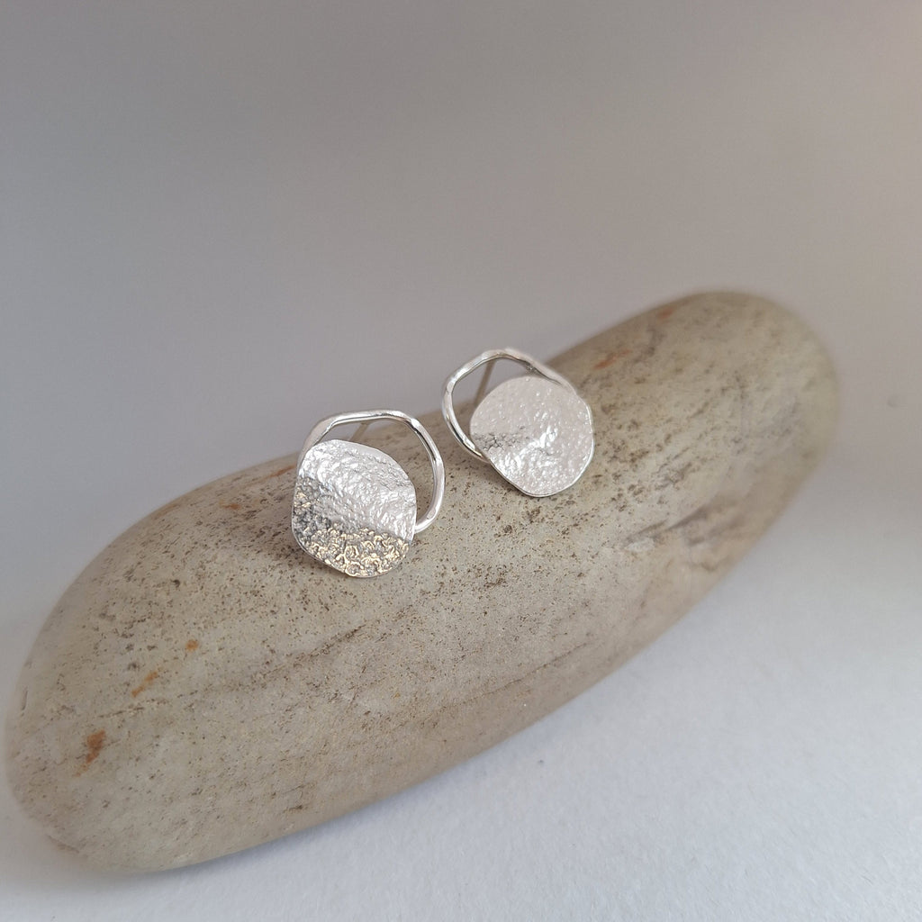 Sterling Silver Beach Boulder shaped stud earring in sterling silver on rock.