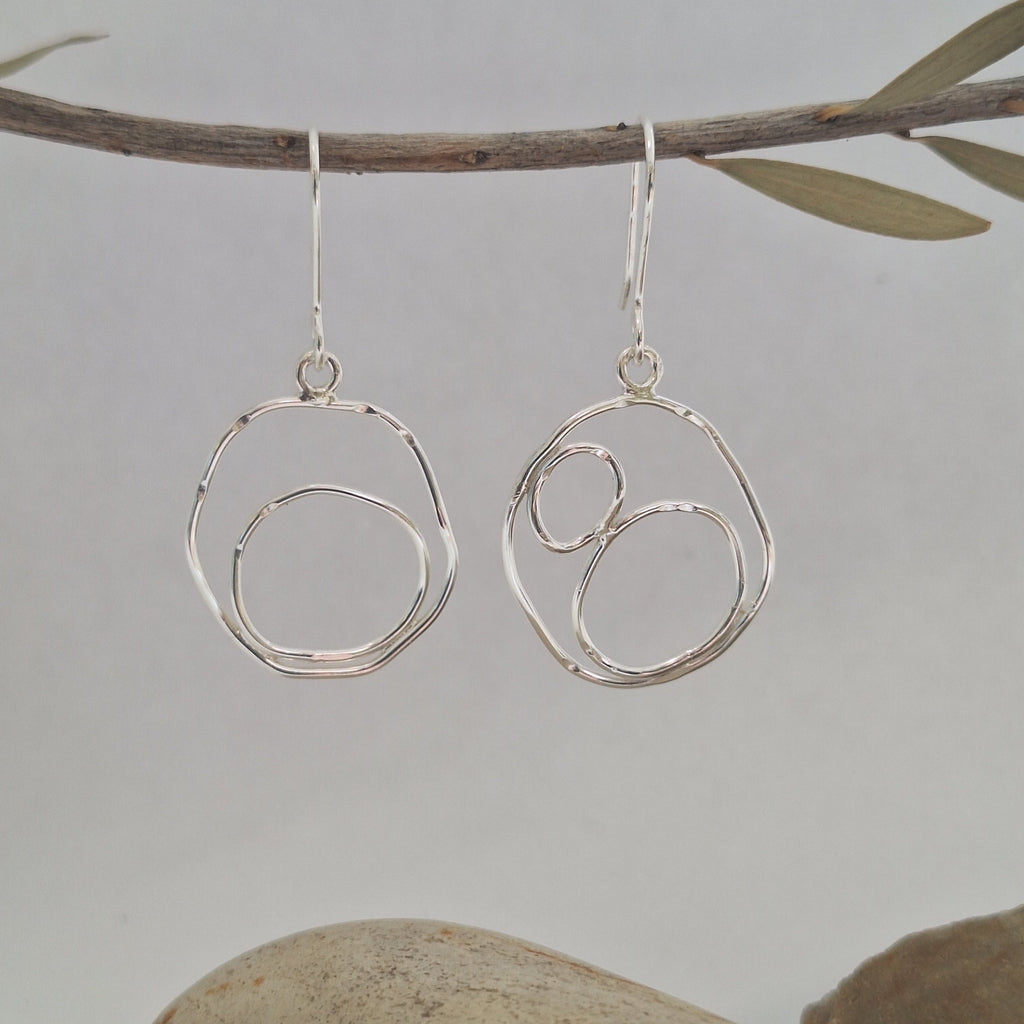 Sterling Silver Beach Boulder shape earrings in sterling silver hanging.