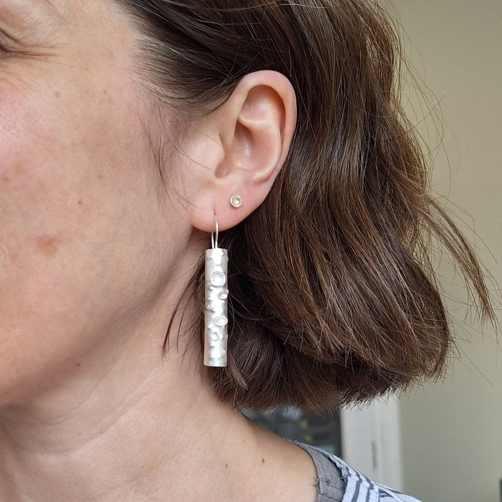 Sterling silver lichen branch earrings on ear