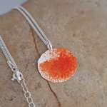 Load image into Gallery viewer, Orange and sterling silver necklace on rock
