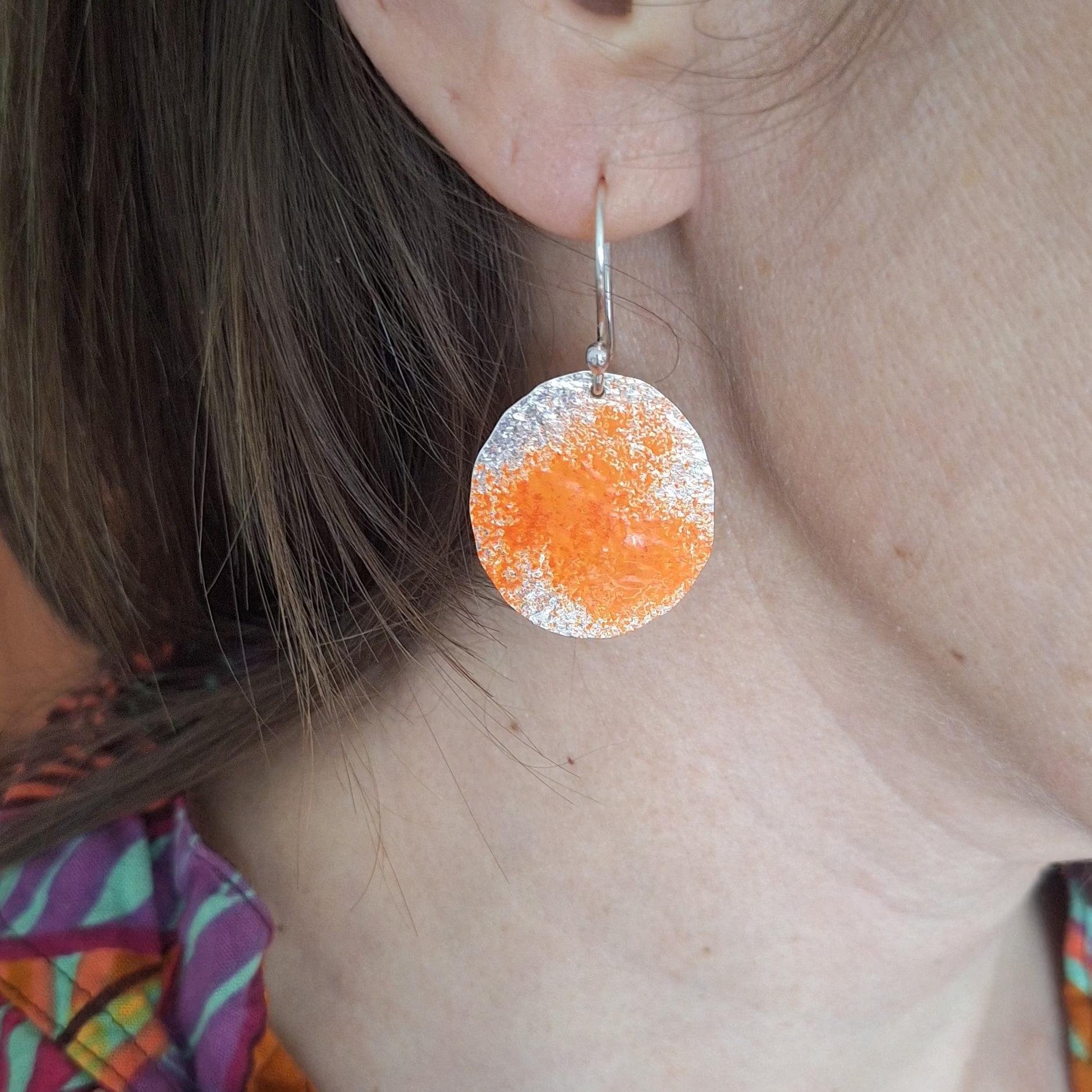 Sterling silver dangle earring with orange powder coat to represent lichens on boulders of tassie east coast.