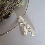 Load image into Gallery viewer, Silver lichen inspired pendant on a white background with natural wood and lichen branch in the corner
