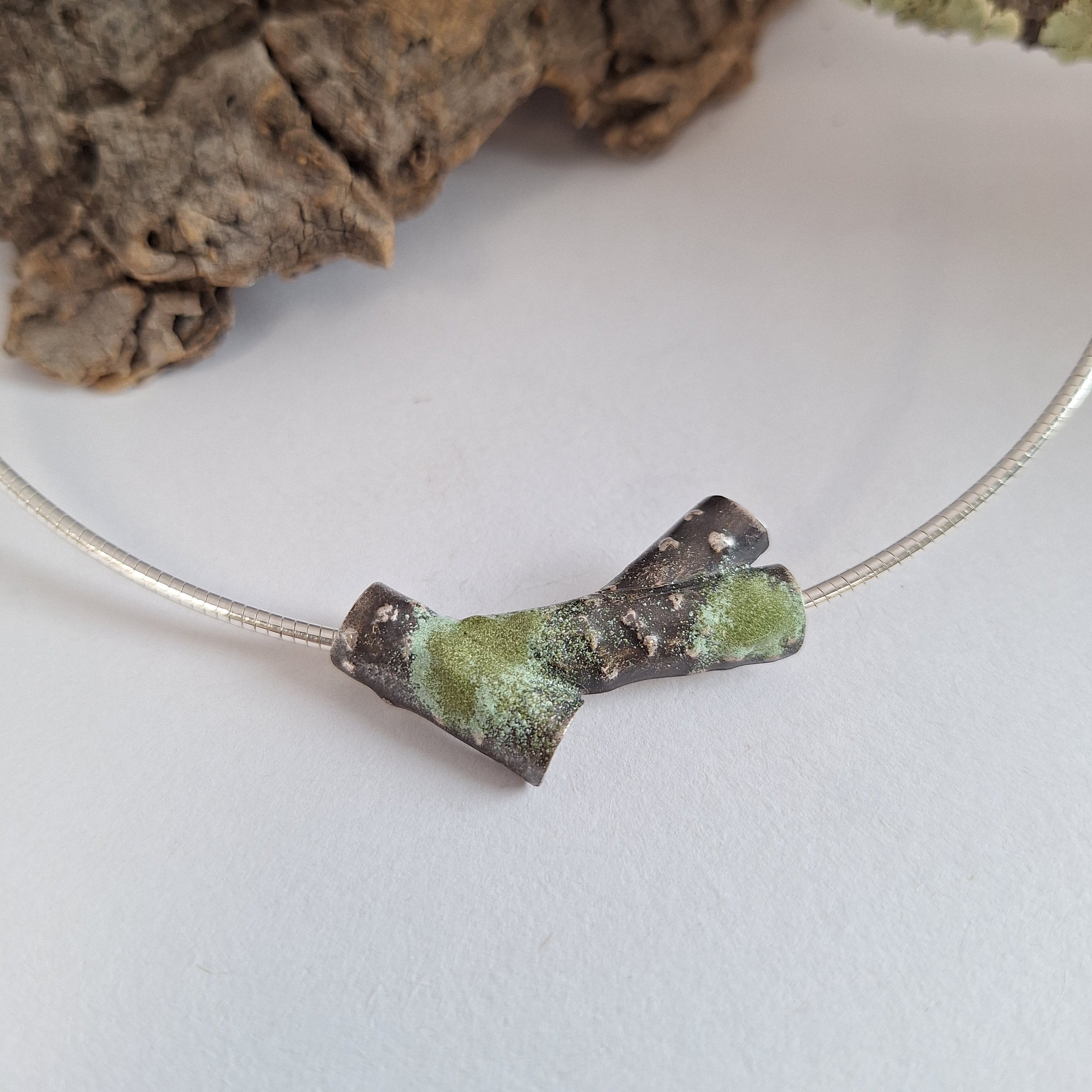 Oxidised blackened sterling silver forest lichen inspired necklace on a extendable omega chain with bark texture and green powder coated lichens