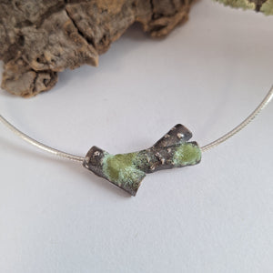 Oxidised blackened sterling silver forest lichen inspired necklace on a extendable omega chain with bark texture and green powder coated lichens