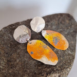 Load image into Gallery viewer, Recycled sterling silver sunburst  dangle statement lichen earrings on a rock.
