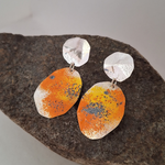 Load image into Gallery viewer, Recycled sterling silver sunburst  dangle statement lichen earrings on a rock.
