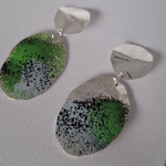 Load image into Gallery viewer, Earrings inspired by crustose lichen on rock. Textured Sterling silver dangle earring with green, black and grey powder coat photographed on a white background.
