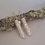 Load image into Gallery viewer, Sterling silver lichen inspired earrings resting on a lichen covered branch
