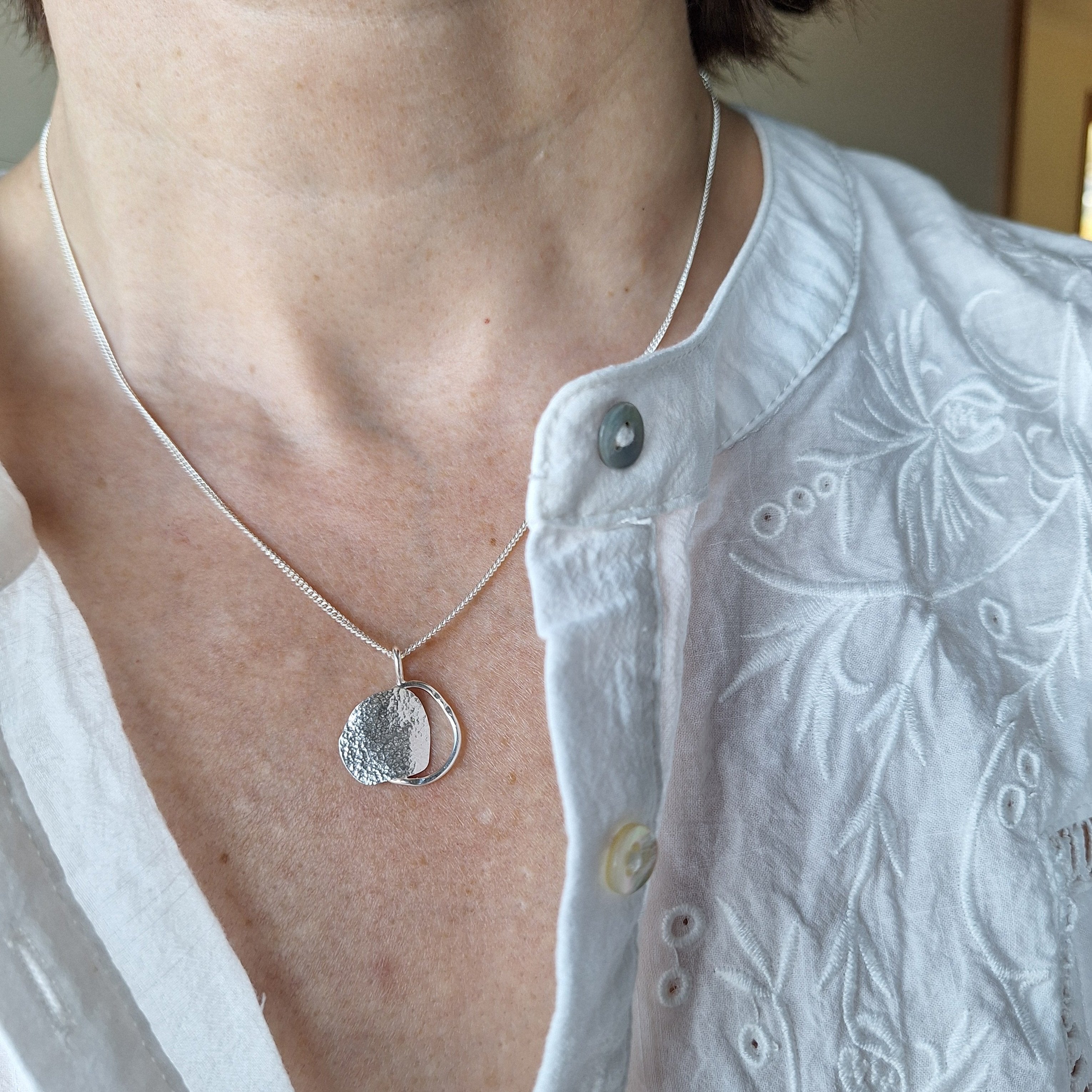 Sterling silver organic shape beach boulder inspired necklace on neck. Handmade in Tasmania by Karen Visagie from Hulley Jewellery 