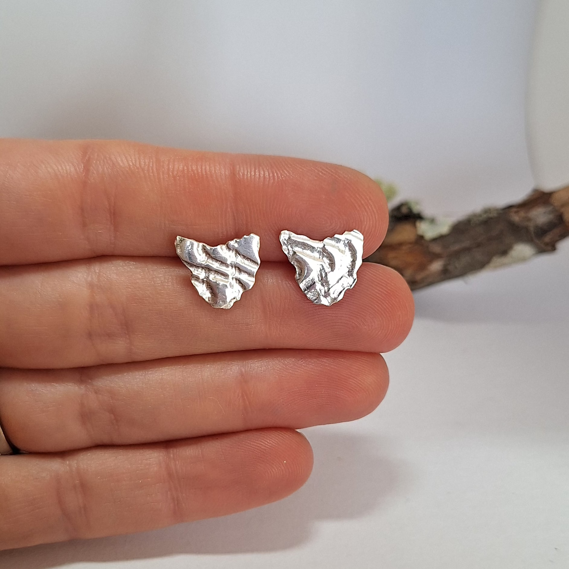 Sterling Silver Tasmania stud Earrings held in hand.
