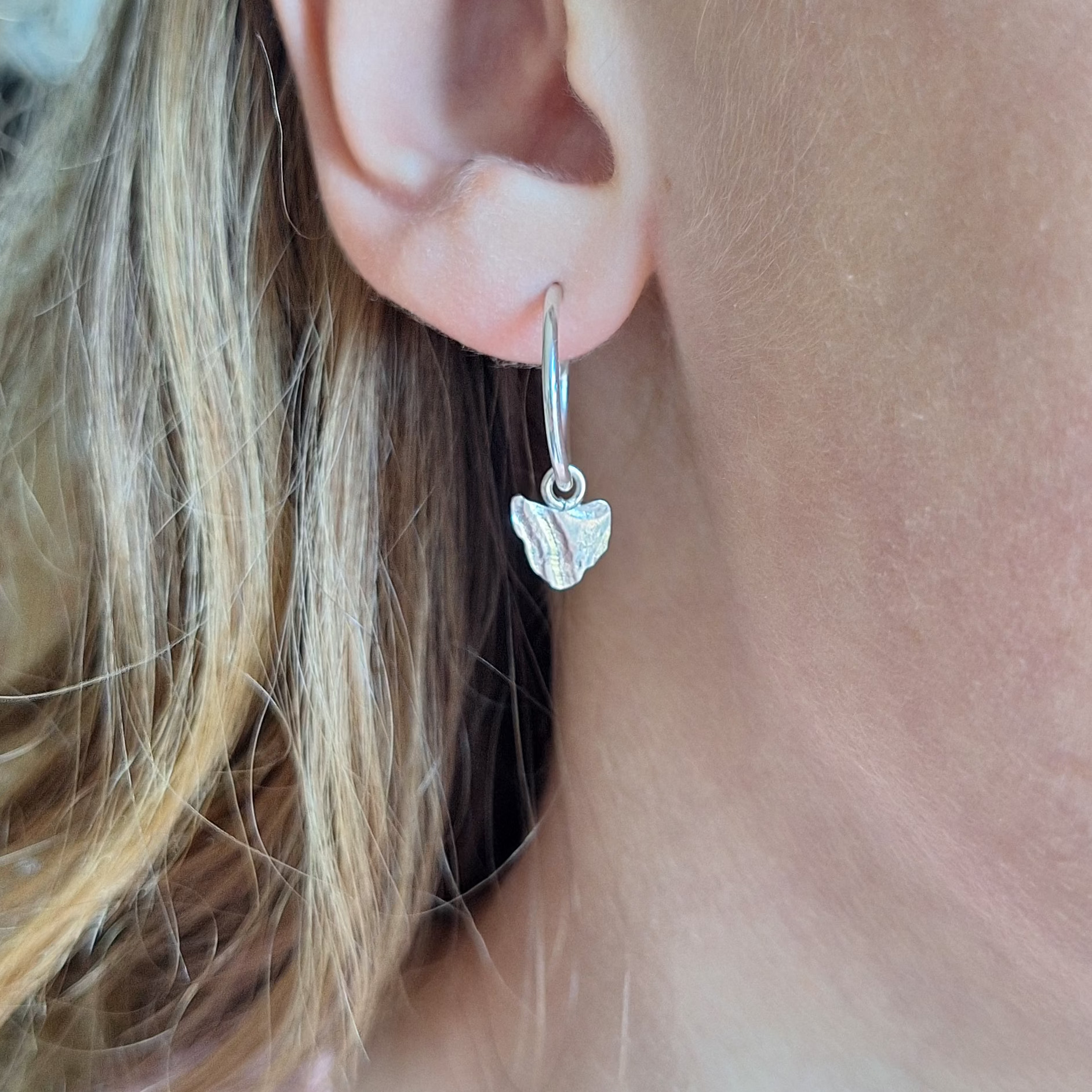 Tasmania hoop earrings in Sterling silver on ear.